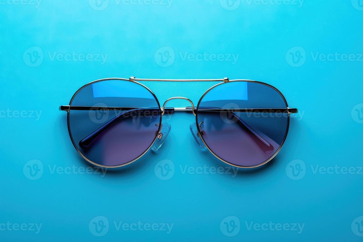 Stylish round sunglasses with colored lenses on a blue background photo