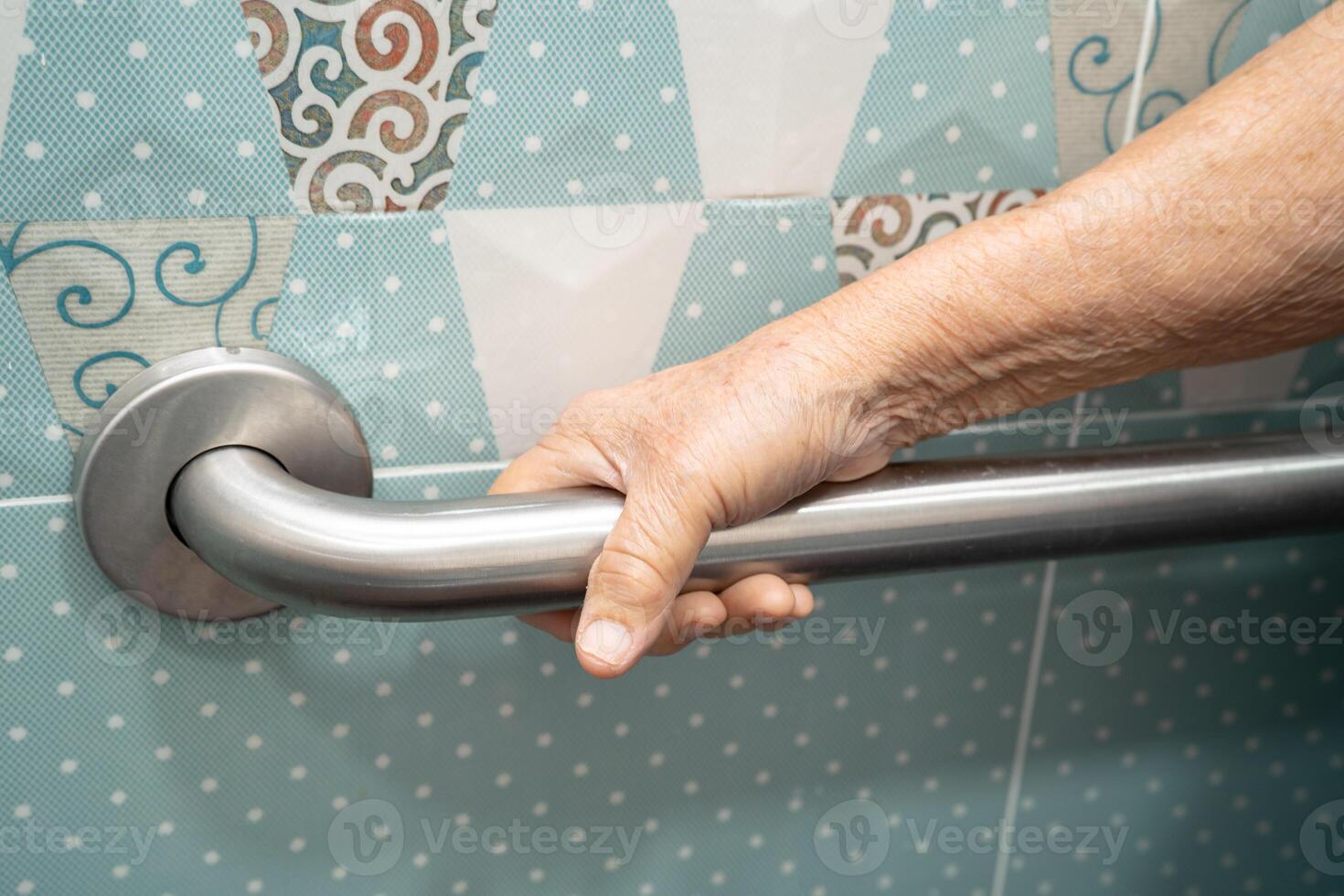 Asian elderly woman patient use toilet bathroom handle security in nursing hospital, healthy strong medical concept. photo