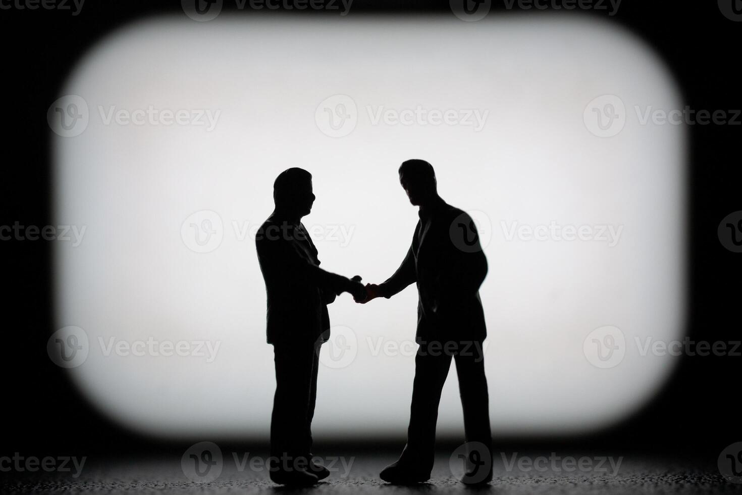Miniature businessman in a professional agreement, with a blurred background to emphasize the interaction. photo