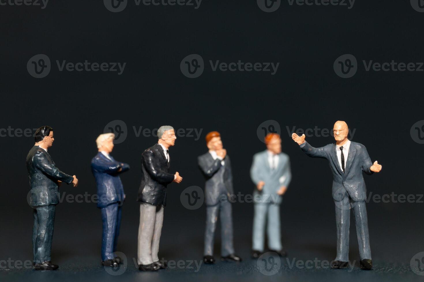 Miniature people Businessman standing on black background , Concept of Business leader and teamwork photo