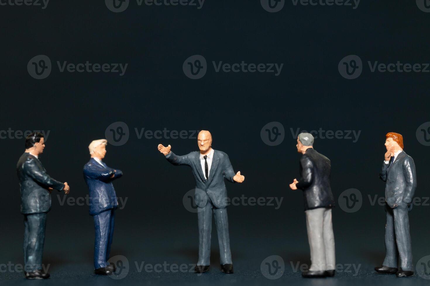 Miniature people Businessman standing on black background , Concept of Business leader and teamwork photo