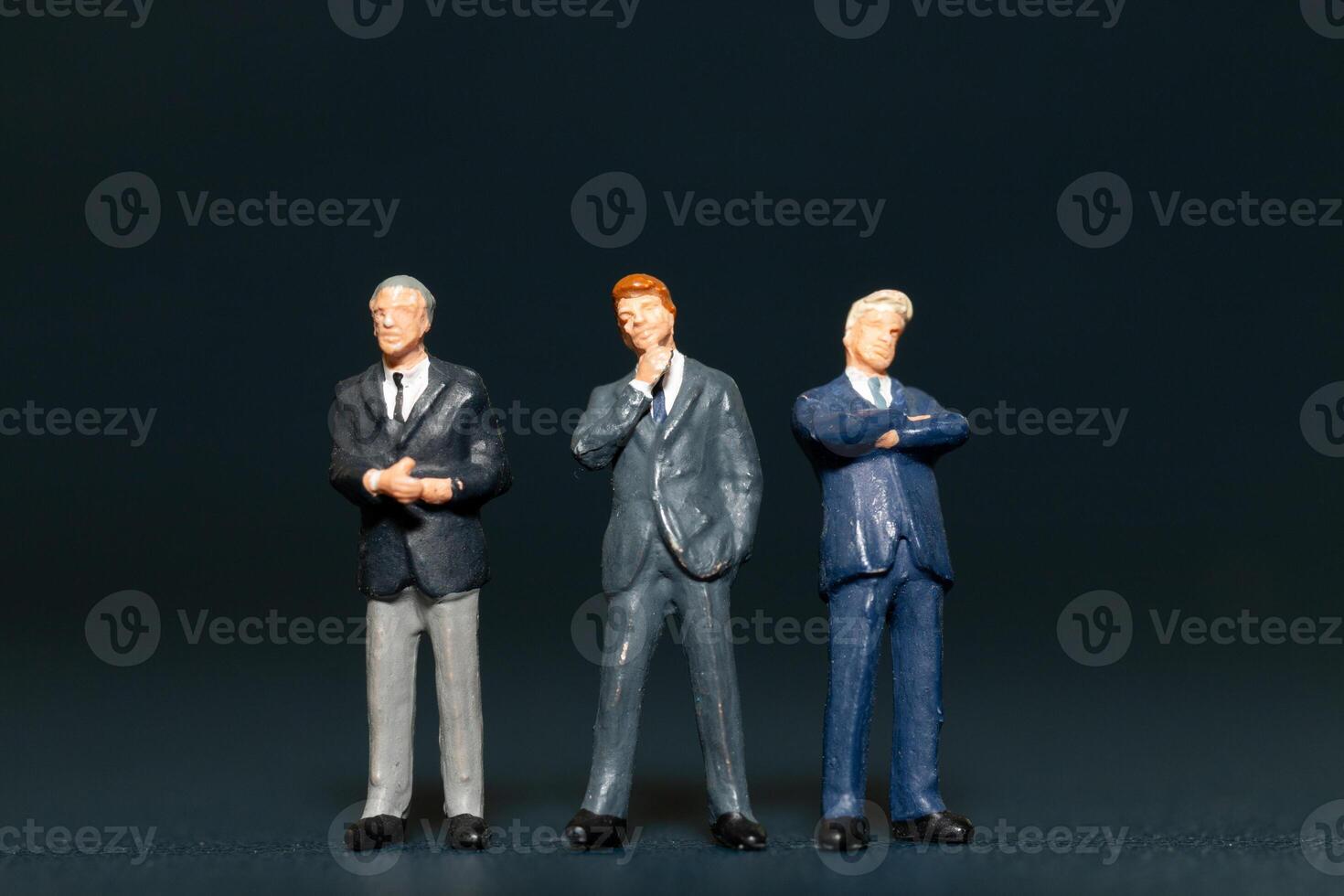 Miniature people Businessman standing on black background , Concept of Business leader and teamwork photo