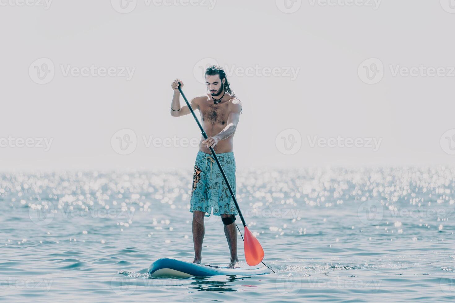 Man Sup Sea. Strong athletic man learns to paddle sup standing on board in open sea ocean on sunny day. Summer holiday vacation and travel concept. Aerial view. Slow motion photo