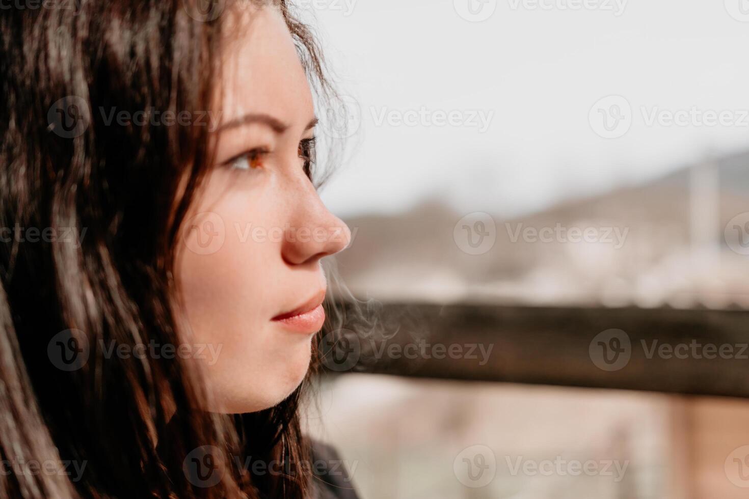 Happy young smiling woman with freckles outdoors portrait. Soft sunny colors. Outdoor close-up portrait of a young brunette woman and looking to the camera, posing against autumn nature background photo