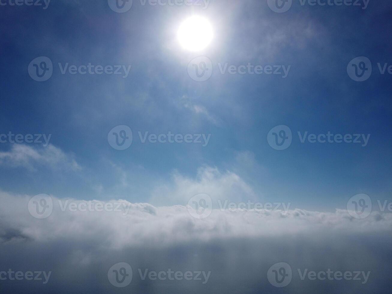 Aerial view. The drone flies over foggy and fluffy clouds. Blue sky sun and sea fog. Abstract aerial nature summer ocean sunset sea and sky background. Vacation, travel and holiday concept photo