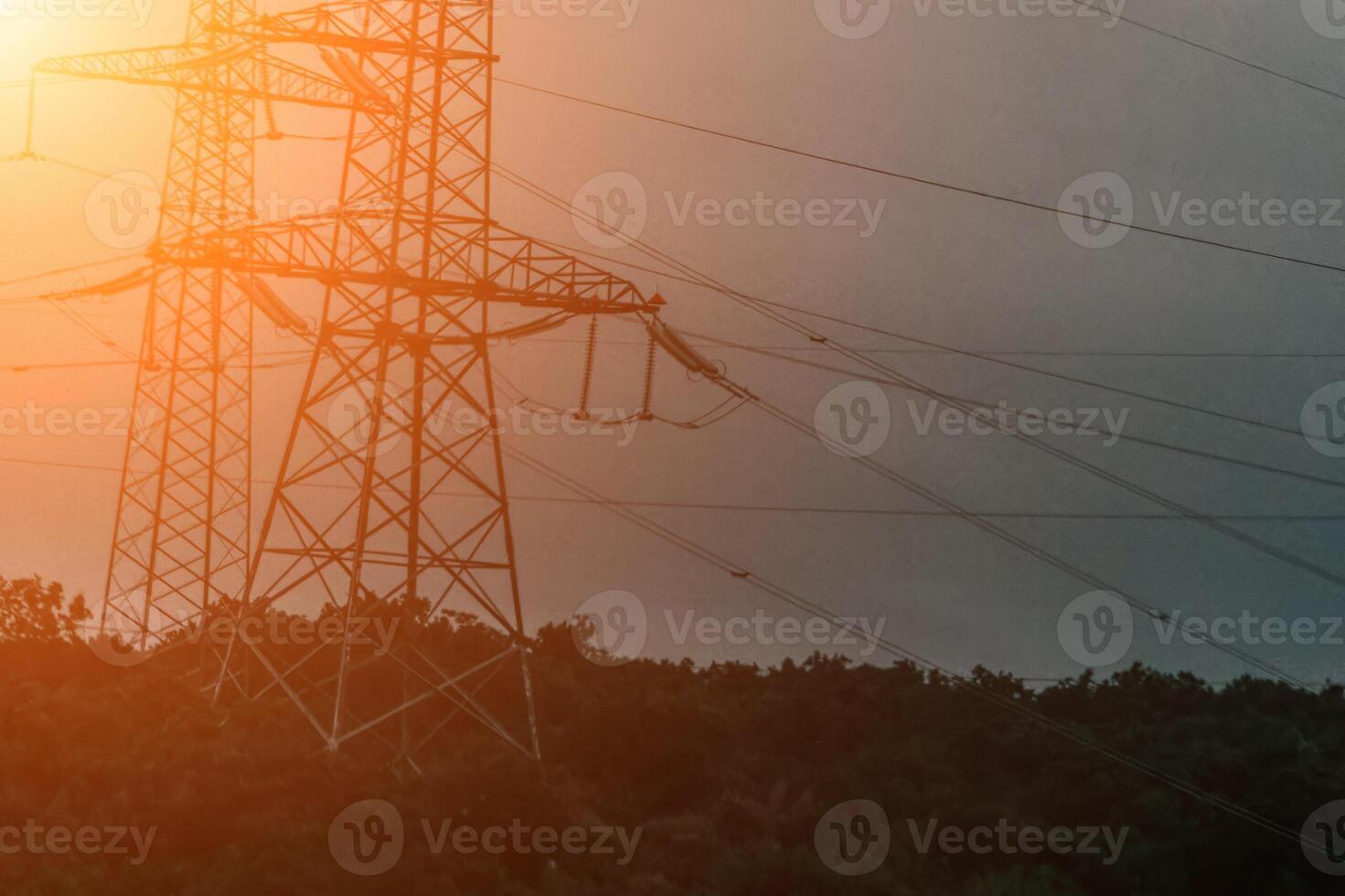 High voltage electric distribution network at sunset. Power transmission lines on supports with ceramic insulators and transformers at large electrical distribution substation photo