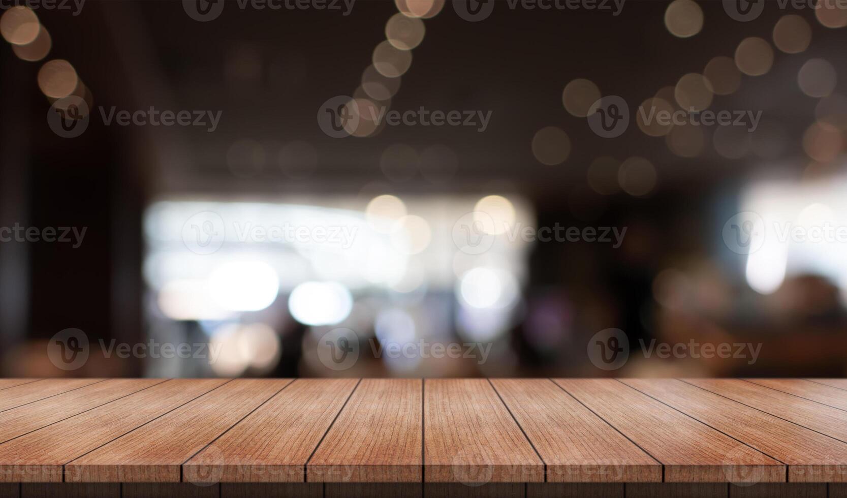Empty wooden table top with lights bokeh on blur restaurant background photo