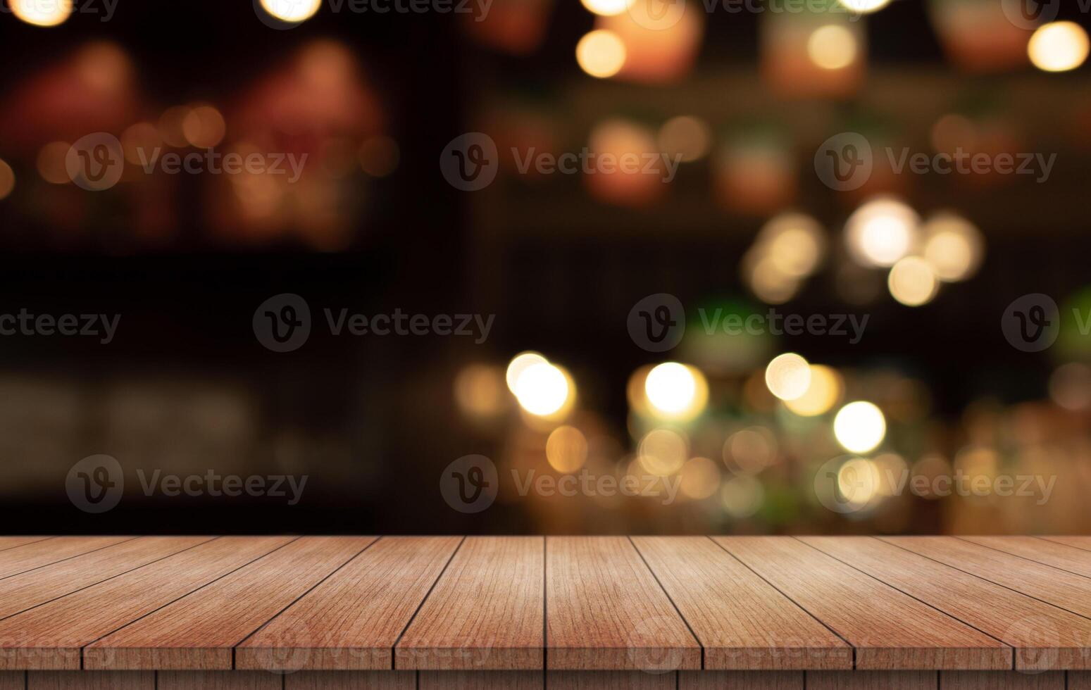 Empty wooden table top with lights bokeh on blur restaurant background photo