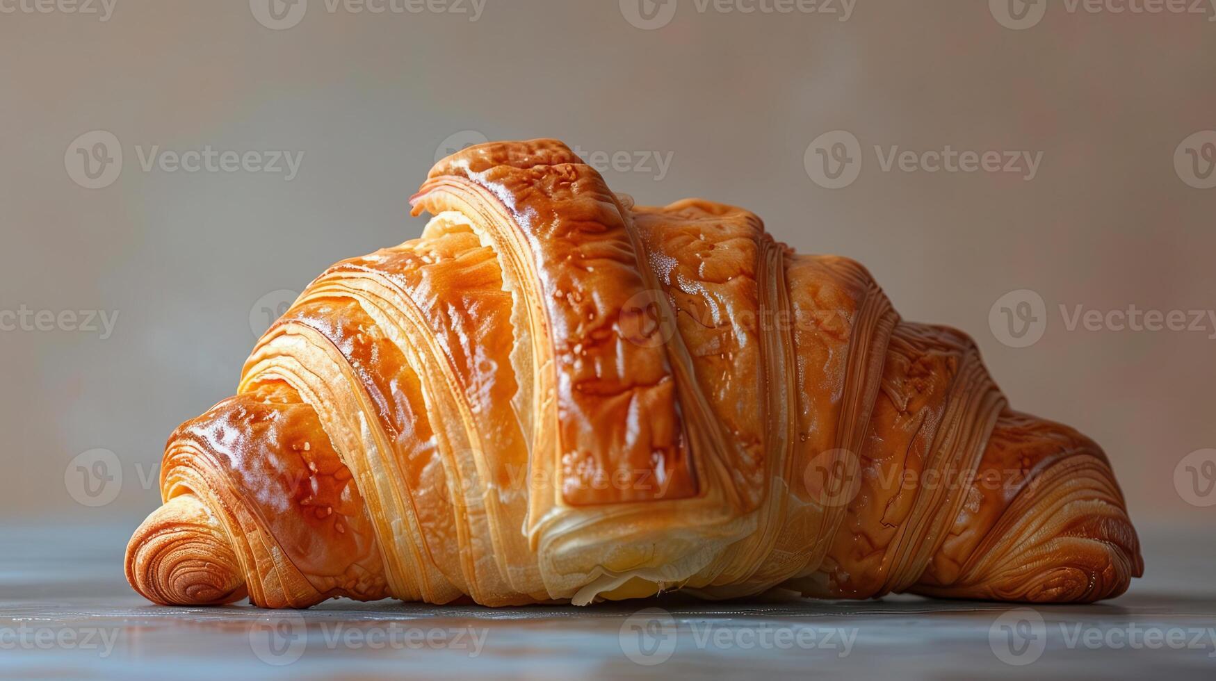 Freshly baked croissant with golden layers, symbolizing indulgence and the delight of breakfast or a coffee break. photo