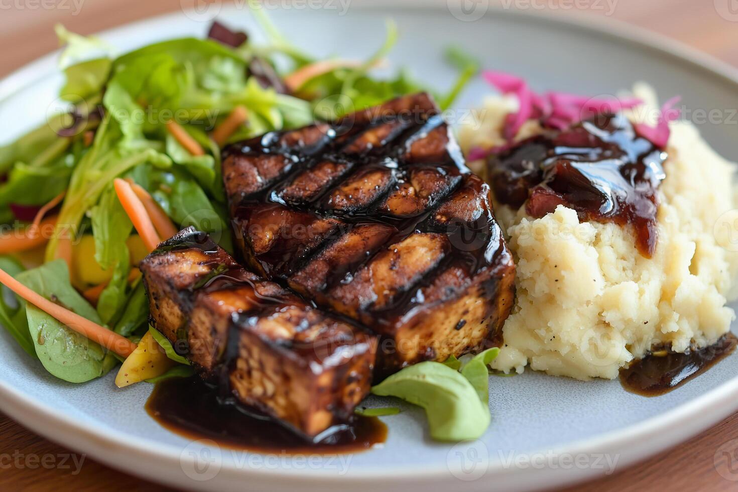 Pan fried balsamic tofu served with mashed potatoes and fresh salad. photo