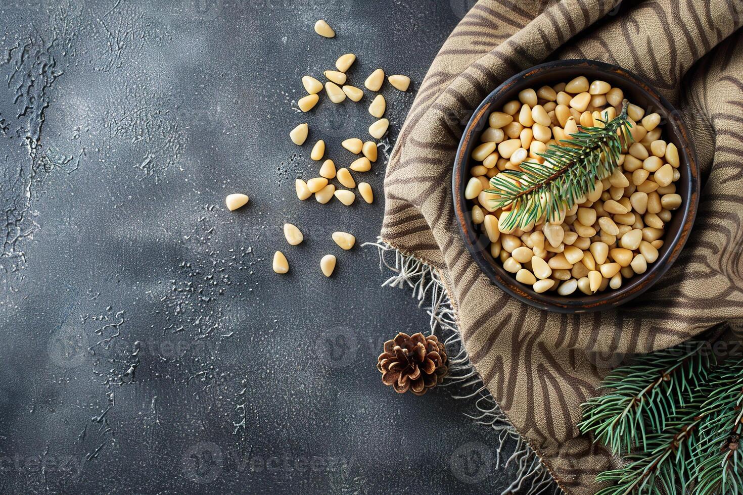 Pine nuts in a bowl with natural decor and rustic fabric on a dark background photo