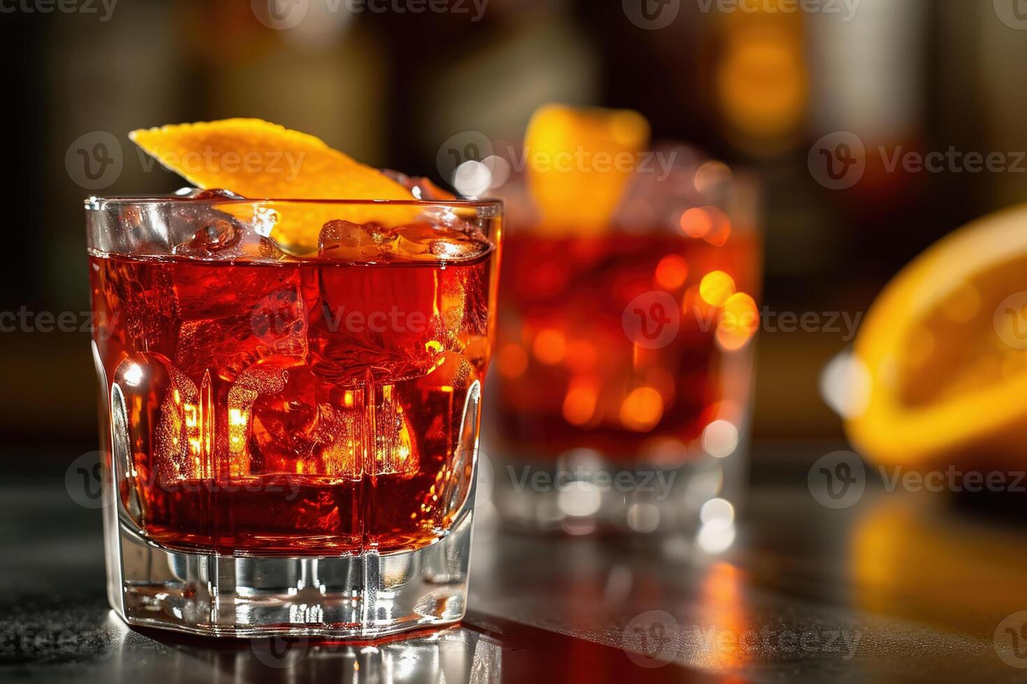 A refreshing Negroni cocktail with ice and orange garnish is served on a bar table photo