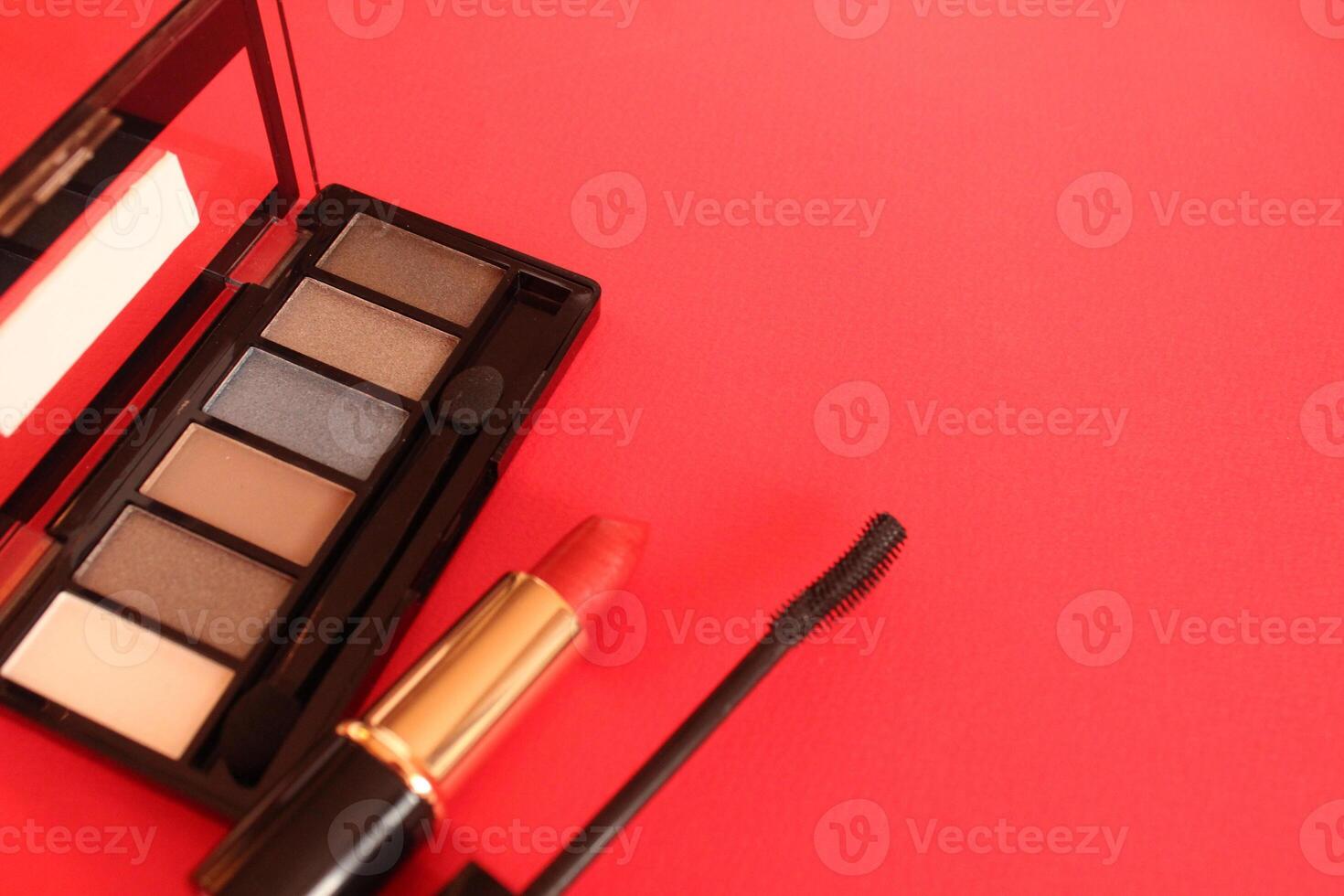 Eye shadow mascara lipstick on a red background with space for text. Make-up and make-up photo