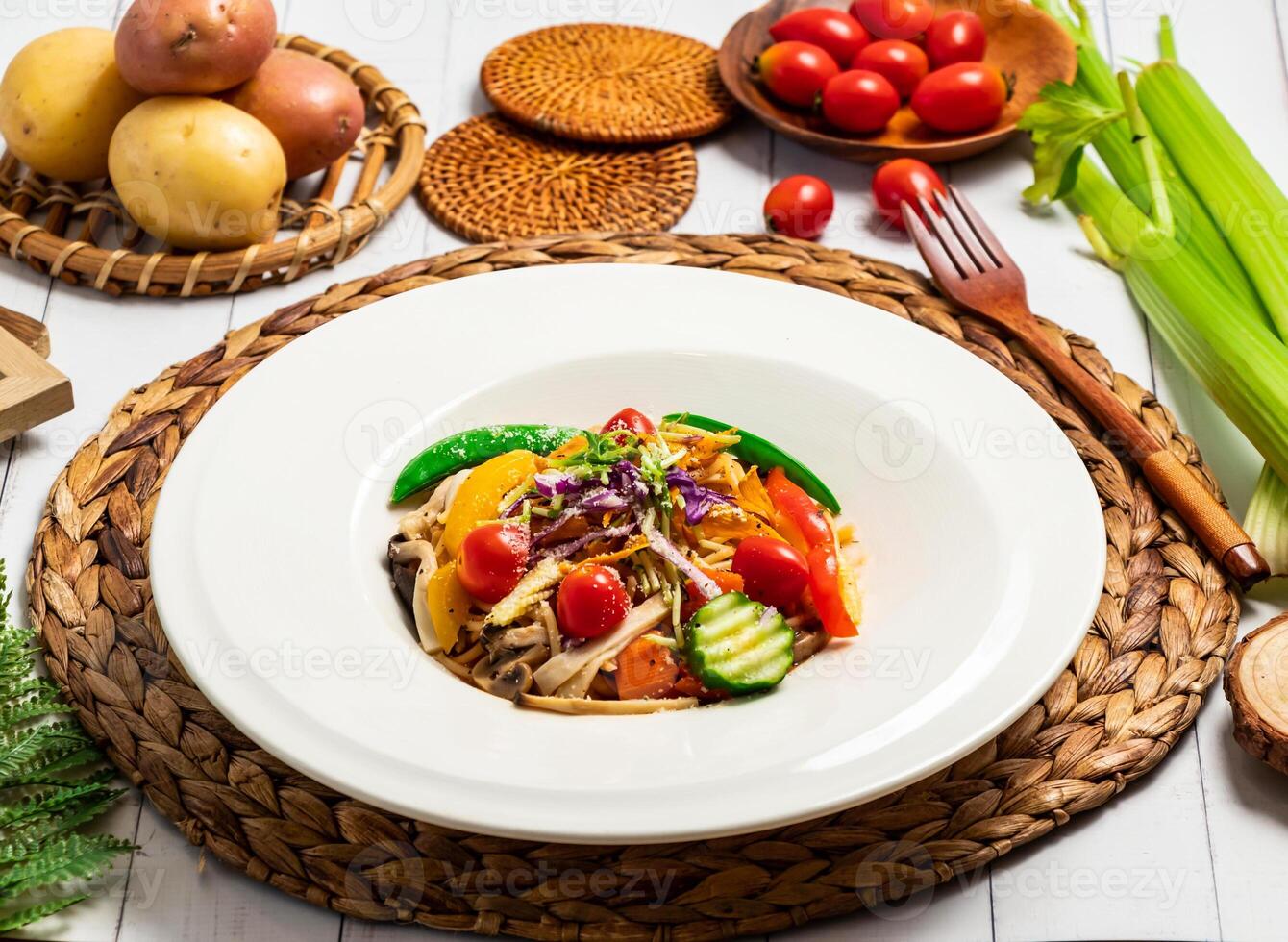 Colorful Vegetable tomato Pasta Salad include cucumber, carrots, bell peppers, mushrooms, and cherry tomatoes in plate isolated on table side view of taiwan food photo