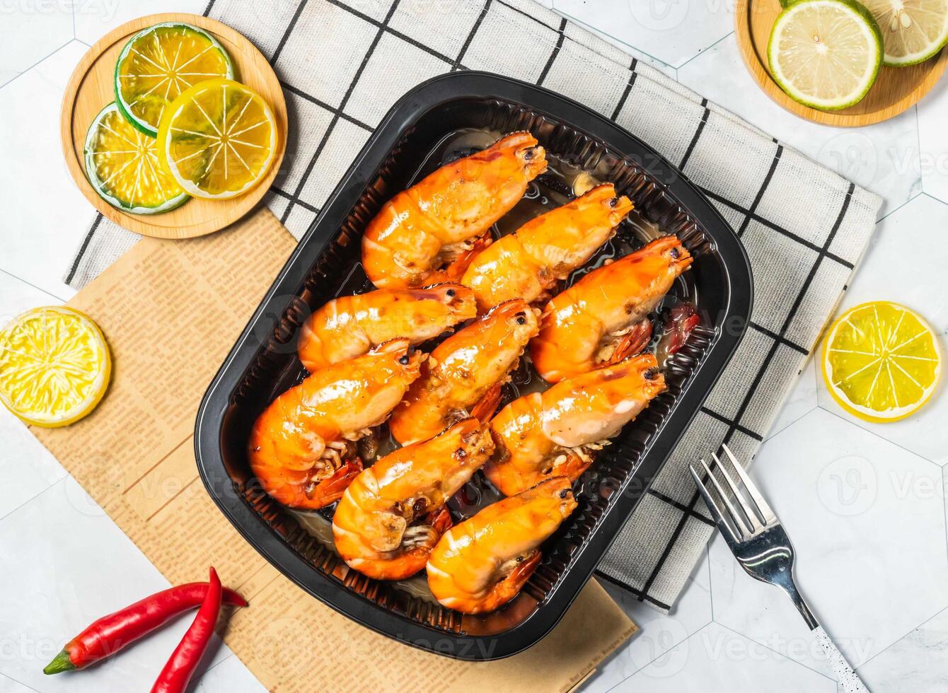Grilled Shrimp with Lemon slice and fork served in black tray isolated on table top view of taiwan seafood photo