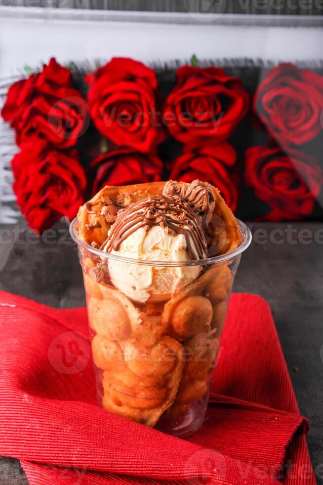 Crushed Waffle Sundae filled with creamy vanilla ice cream chocolate syrup served in glass isolated on background side view of healthy and delicious beverage photo