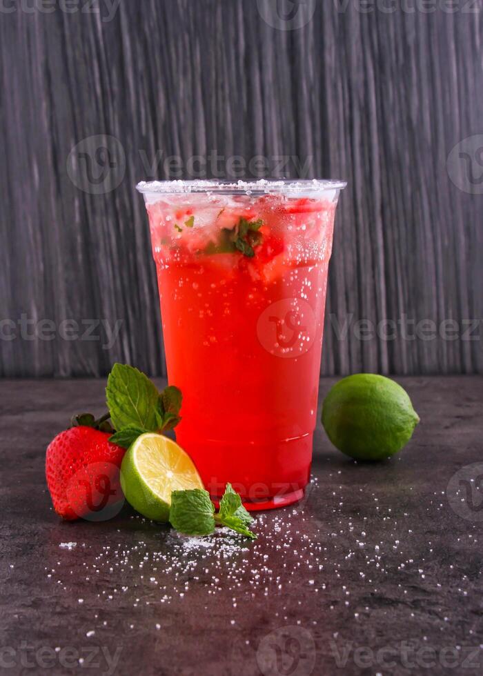 Strawberry lemon Mint Mojito made with Strawberry, lime juice, mint leaves, and sparkling water served in glass isolated dark background side view of healthy drink photo