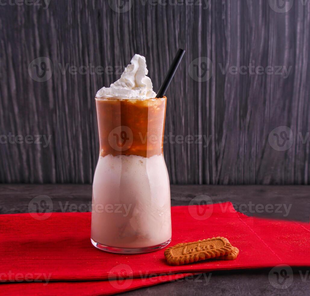 Lotus Tiramisu Milkshake Topped with whipped cream and a sprinkling of cocoa powder served in glass isolated on background side view of dessert drink photo