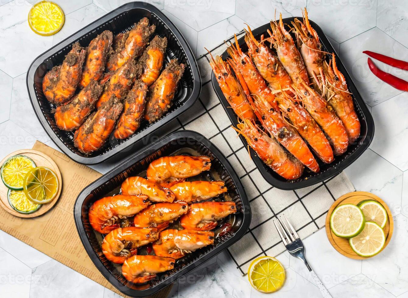 Assorted Grilled Shrimp verity Spicy Pepper Grilled Shrimp with lemon, Salted Grilled Shrimp with Lime slice fork served in black tray isolated on table top view of taiwan seafood photo