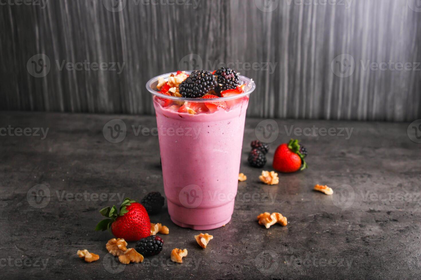 Delicious Strawberry and blackberry Smoothie with Nuts served in glass isolated on background side view of healthy and delicious beverage photo