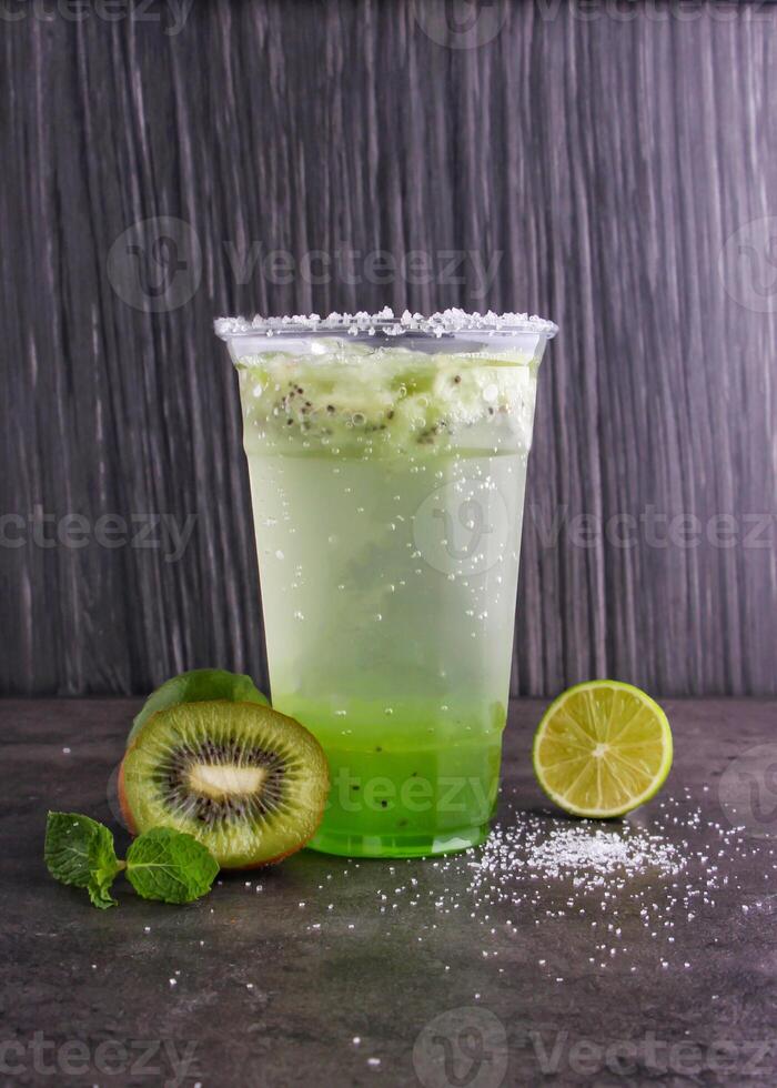 Refreshing Kiwi Mojito made with fresh kiwi slices, lime juice, mint leaves, and sparkling water served in glass isolated on background side view of healthy drink photo