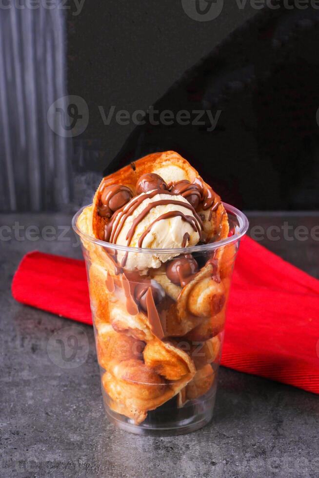 Chocolate Dipped Egg Waffle Cup with vanilla Ice Cream side view of ice dessert photo