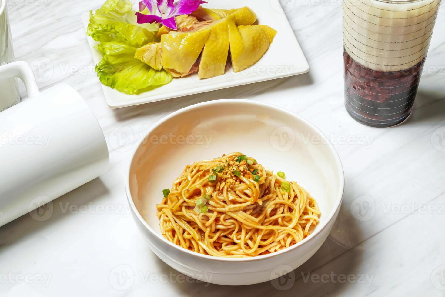 Huadiao tender chicken and sesame noodles with Taiwanese red bean ice tea served in dish isolated on marble background side view of taiwan food photo