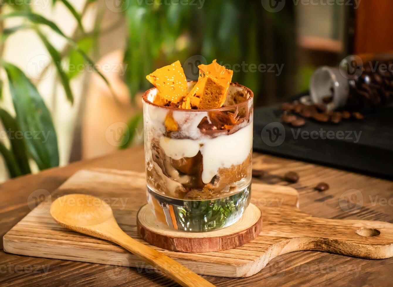 Tiramisu with Honeycomb Crumble served in jar isolated on wooden cutting board side view on table taiwan dessert photo