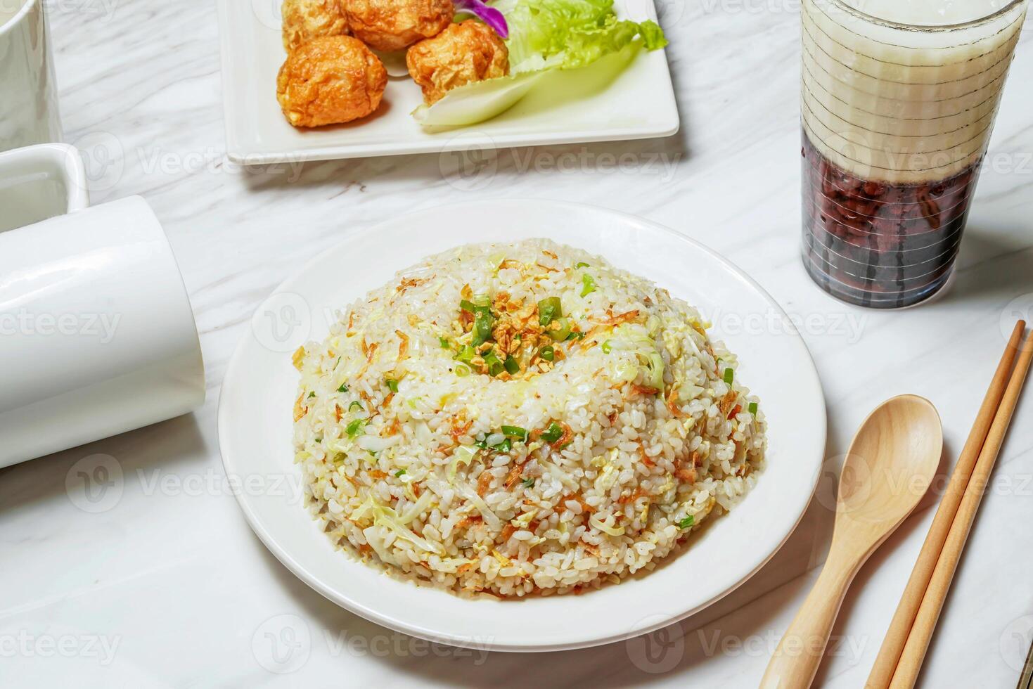 Egg Fried Rice with Dancing Sakura Shrimp, Fried squid balls, Taiwanese red bean ice tea served in dish isolated on marble background side view of taiwan food photo