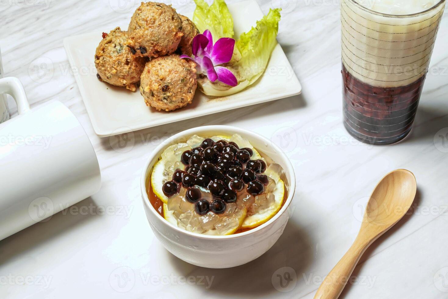 Honey Lemon Aloe vera Aiyu With dace fish balls, Taiwanese red bean ice tea served in dish isolated on marble background side view of taiwan food photo