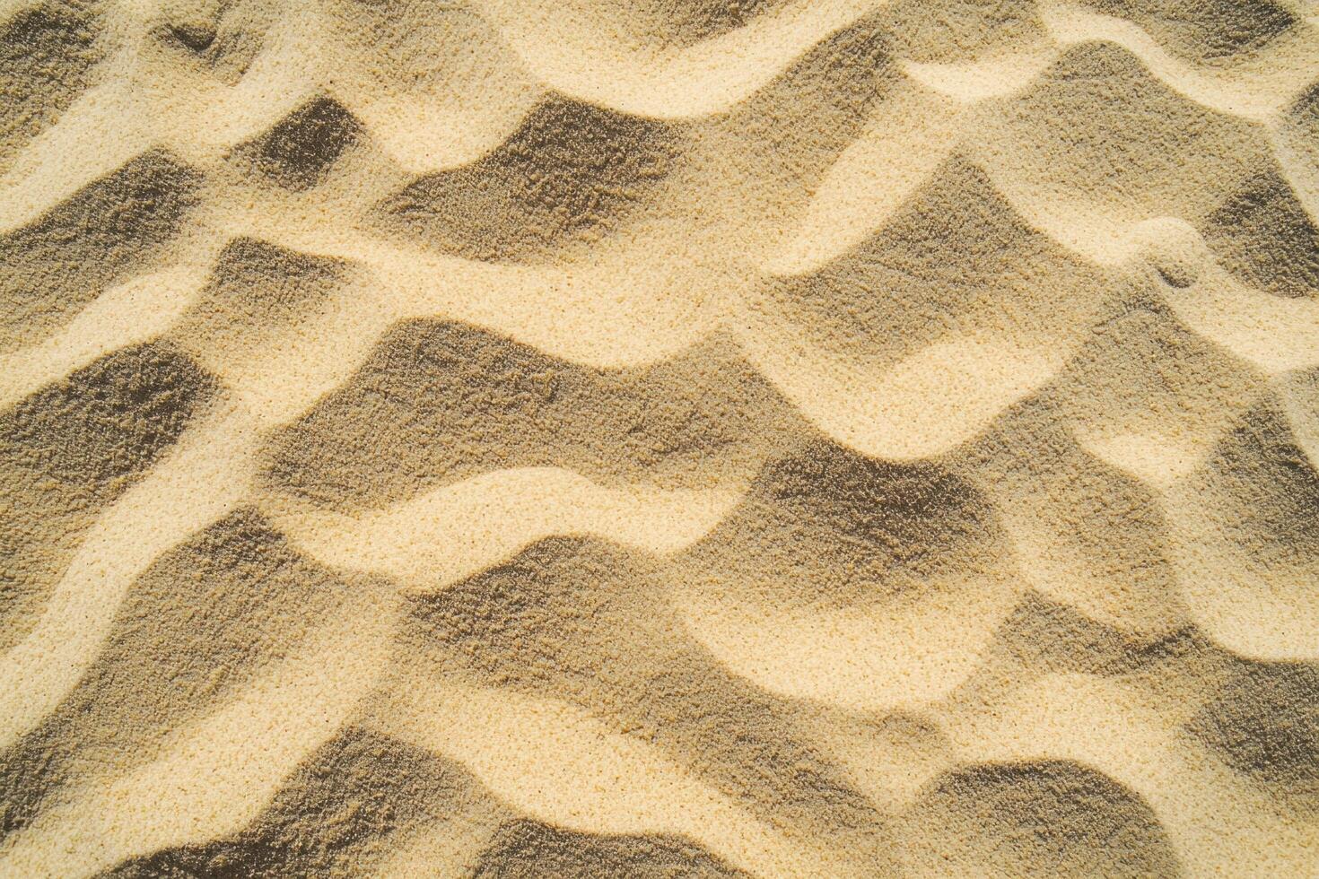 A close-up view of fine sand texture with subtle patterns and varying shades of beige and tan photo