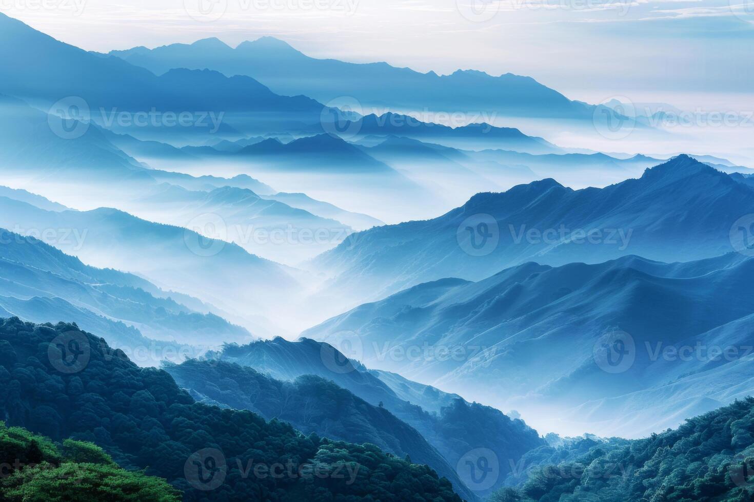 The mountains are covered in trees and the sky is a beautiful shade of blue photo