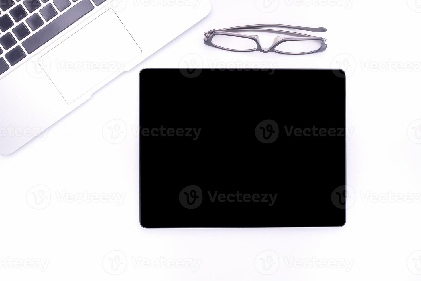 Top view of a blank tablet, laptop and glasses isolated on white background. Space for text. Technology and communication concept photo