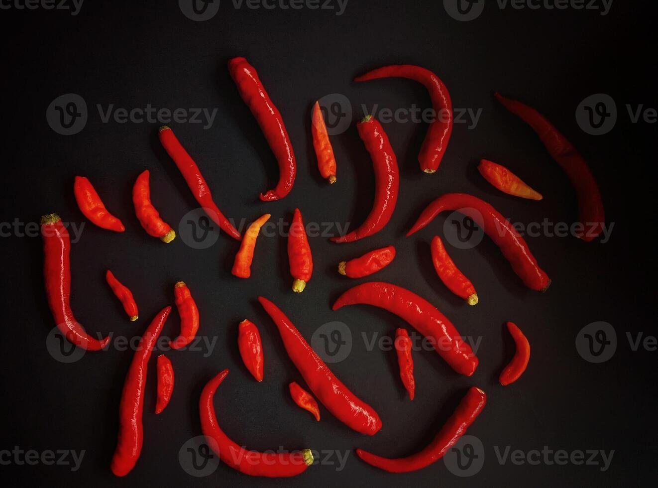 A group of red chili peppers on a black background photo