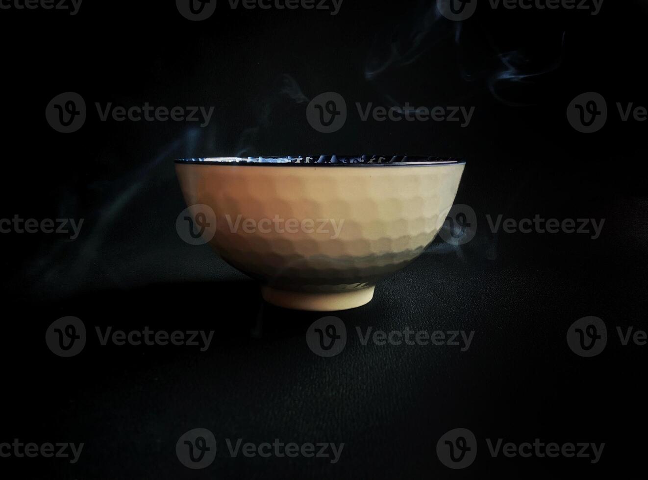 A bowl of tea on a black background photo