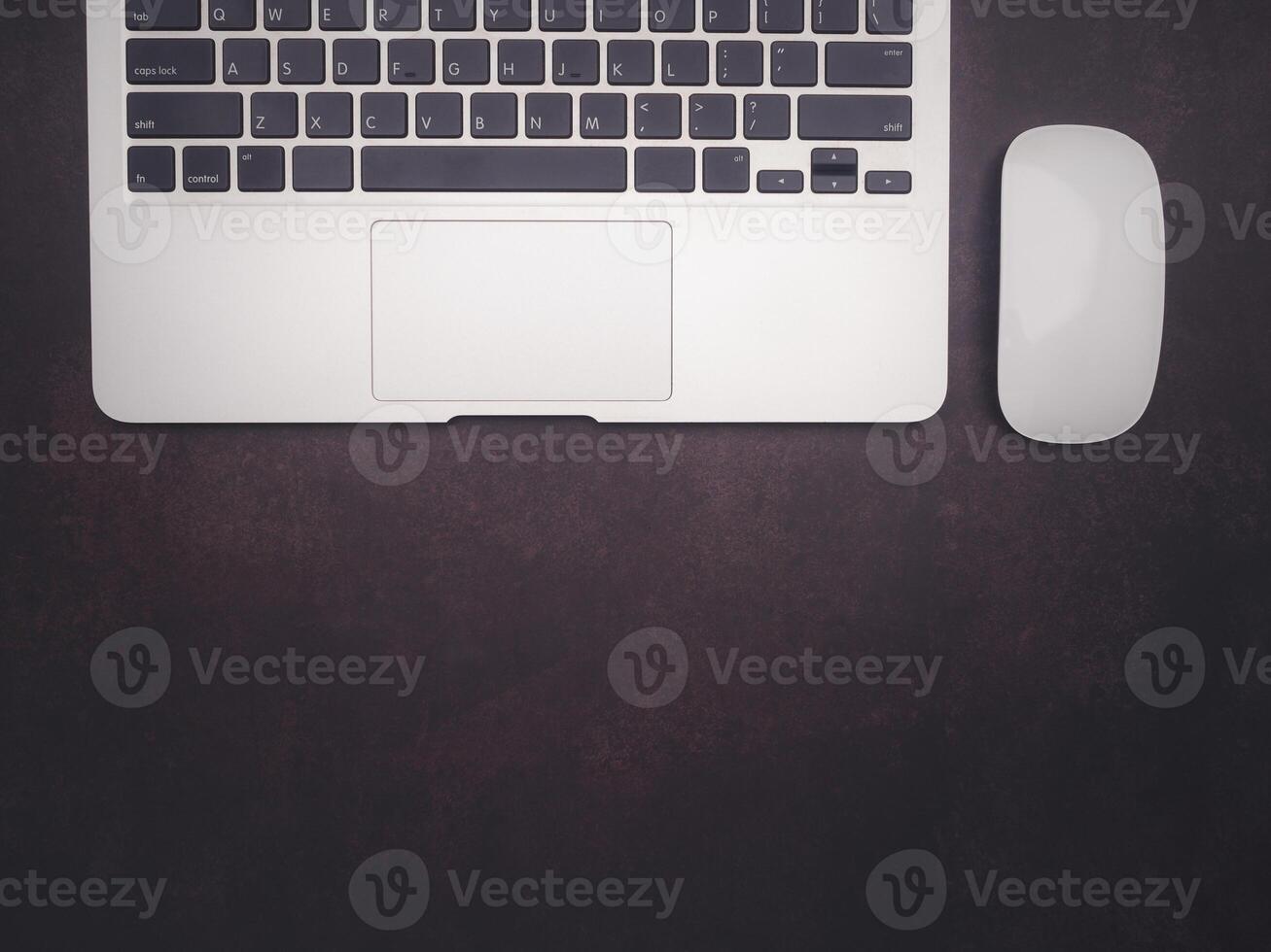 Top view of a laptop and mouse on vintage background with copy space for text. Computer and technology concept photo