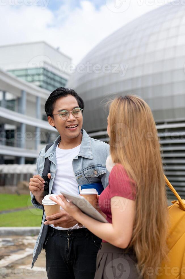 A happy Asian male college student is enjoying a conversation with his friend while walking outdoors photo