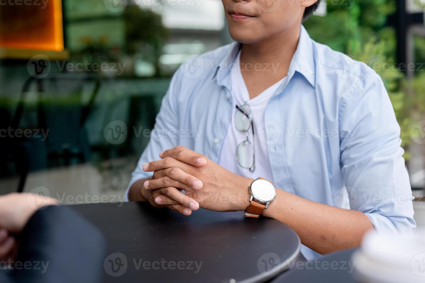 A cropped image of a man is having an informal meeting with his insurance agent at a coffee shop. photo