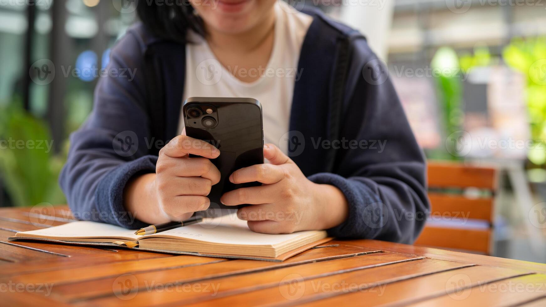 A woman using her phone, reading online articles, or responding to messages while sitting at a cafe. photo
