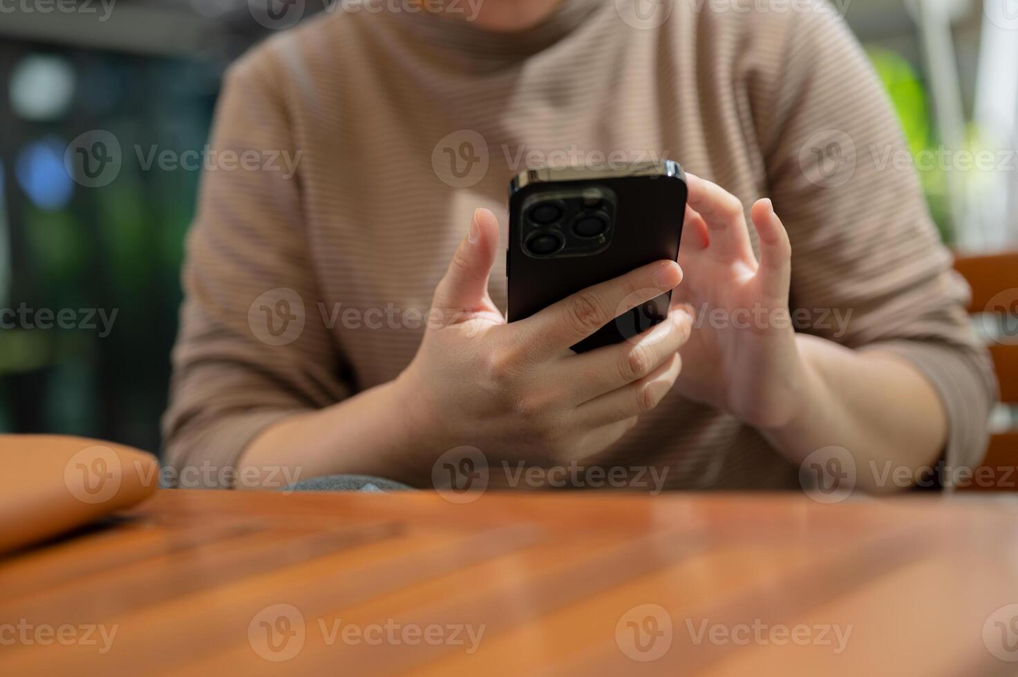 A woman reading online articles on the website while relaxing at an outdoor table in a cafe. photo