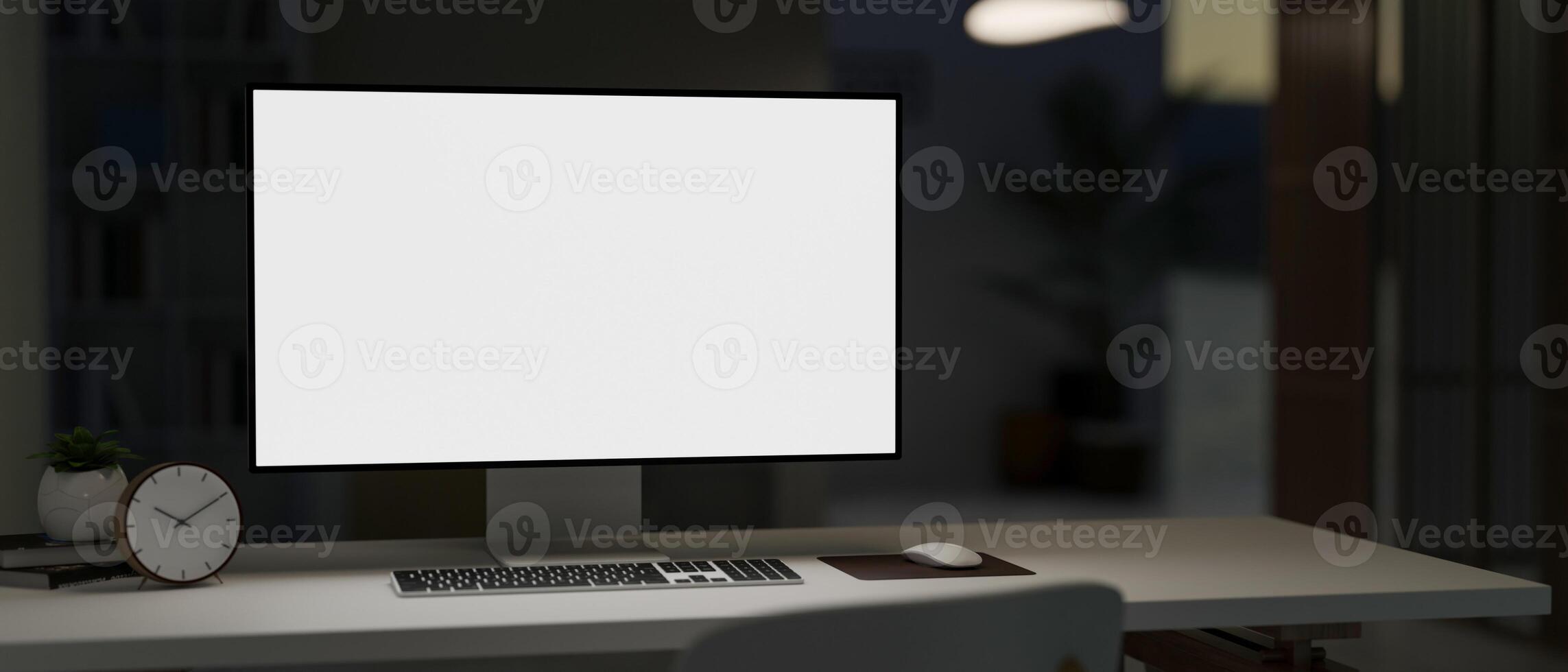 A PC computer white-screen mockup on a white desk in a modern dark office room at night. photo