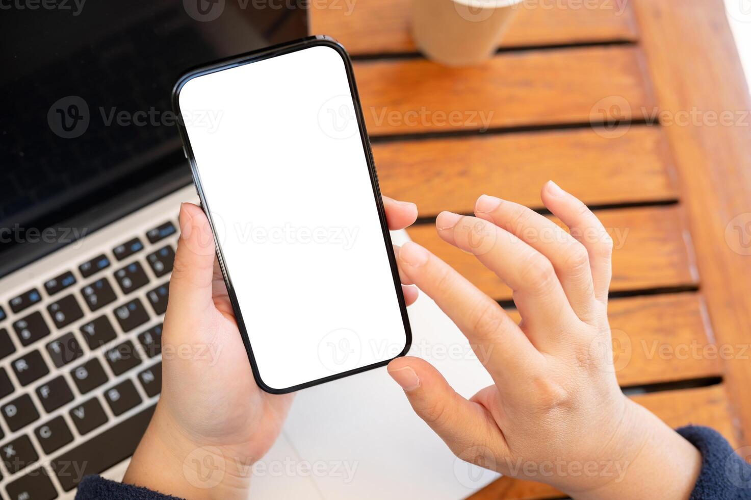 Top view image of a woman using her smartphone while working remotely at a cafe. photo
