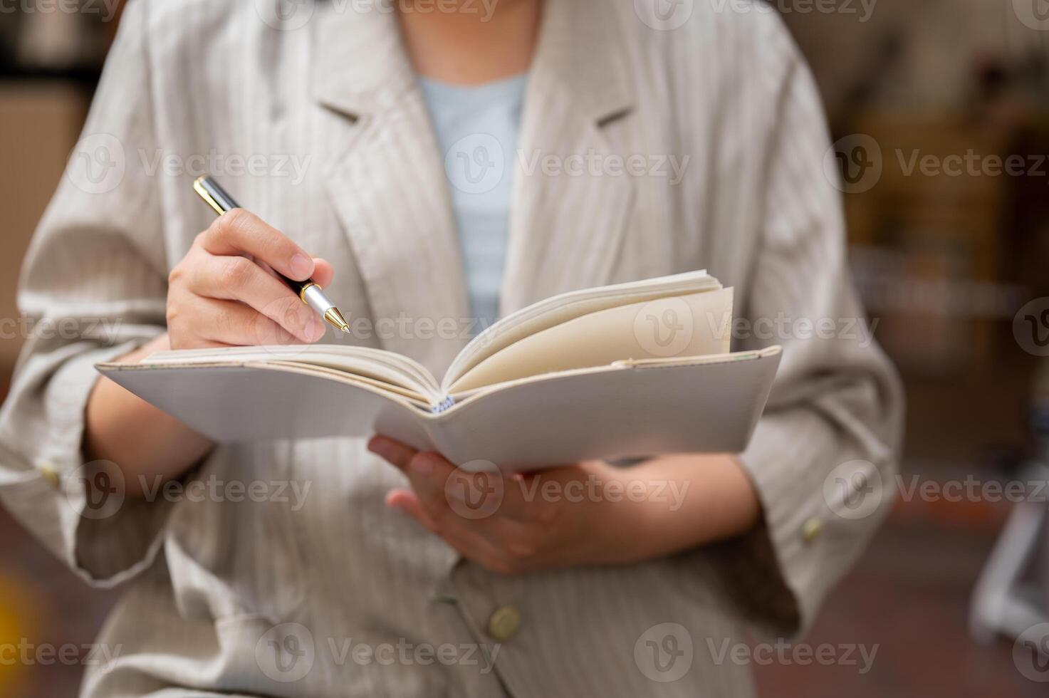 A businesswoman holding her notebook and taking notes in it, listing her ideas. photo