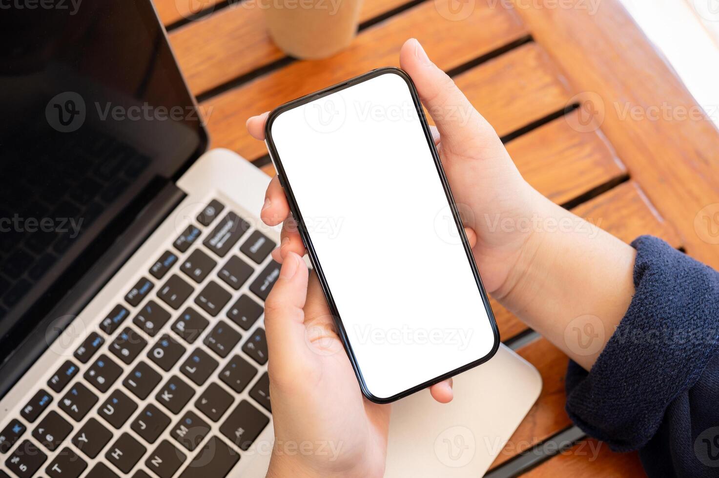 Top view image of a woman using her smartphone while working remotely at a cafe. photo
