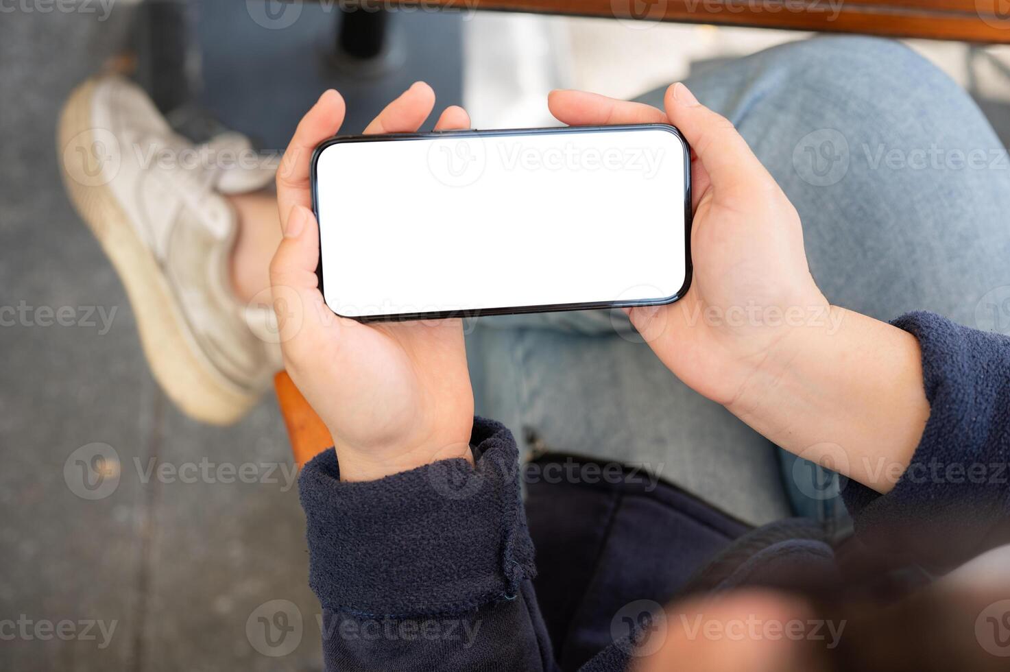 A woman holding a smartphone mockup in a horizontal position. watching videos on a smartphone. photo