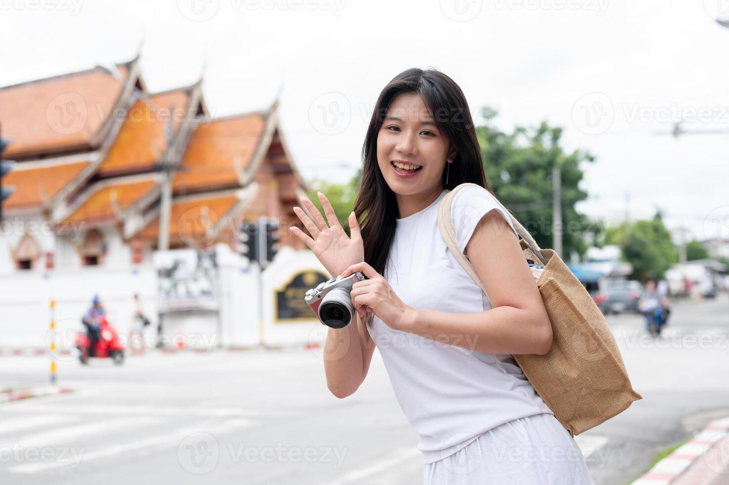 A beautiful Asian woman is standing by the street in the old town city of Chiang Mai, Thailand. photo