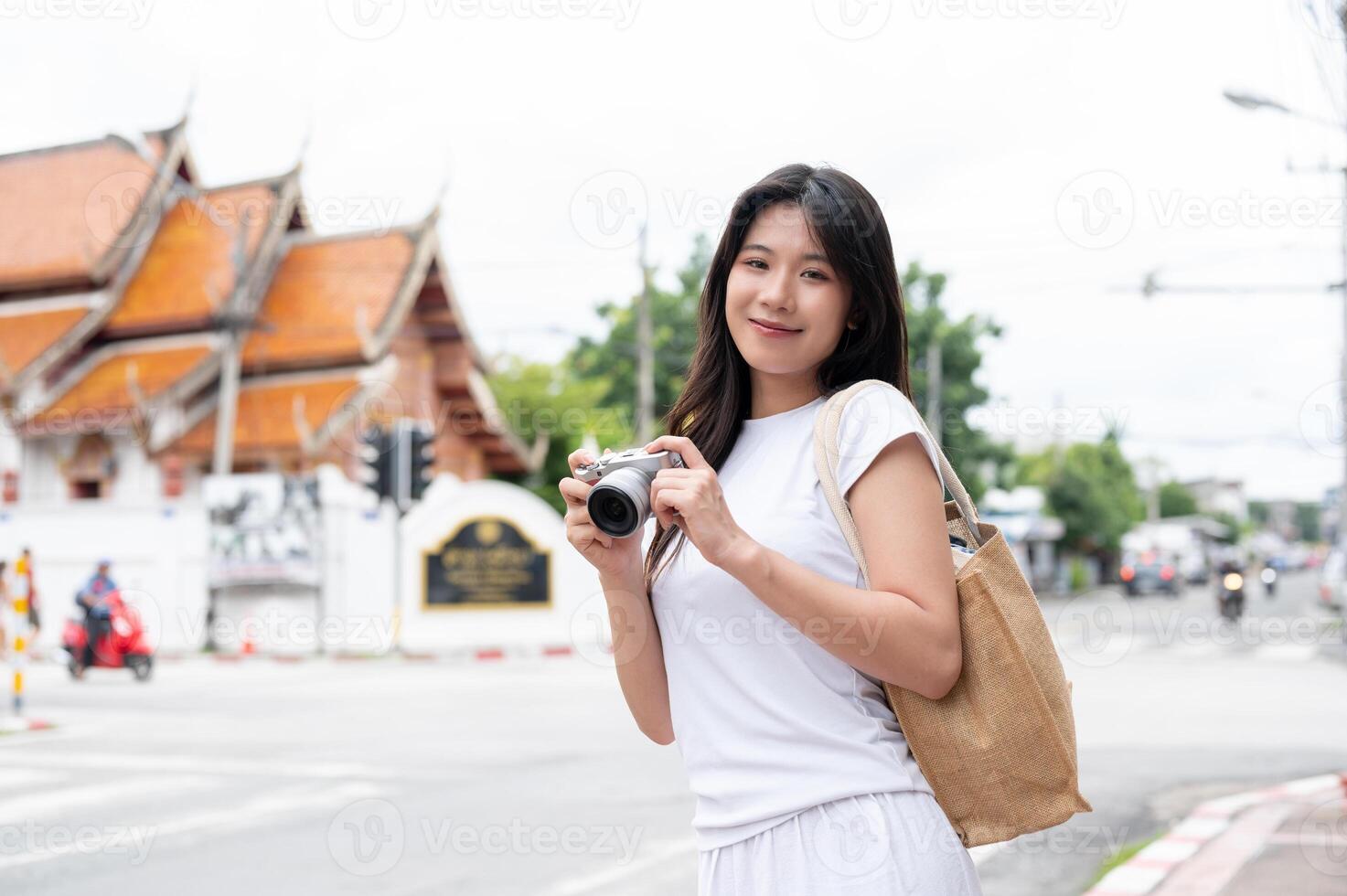 A beautiful Asian woman is standing by the street in the old town city of Chiang Mai, Thailand. photo