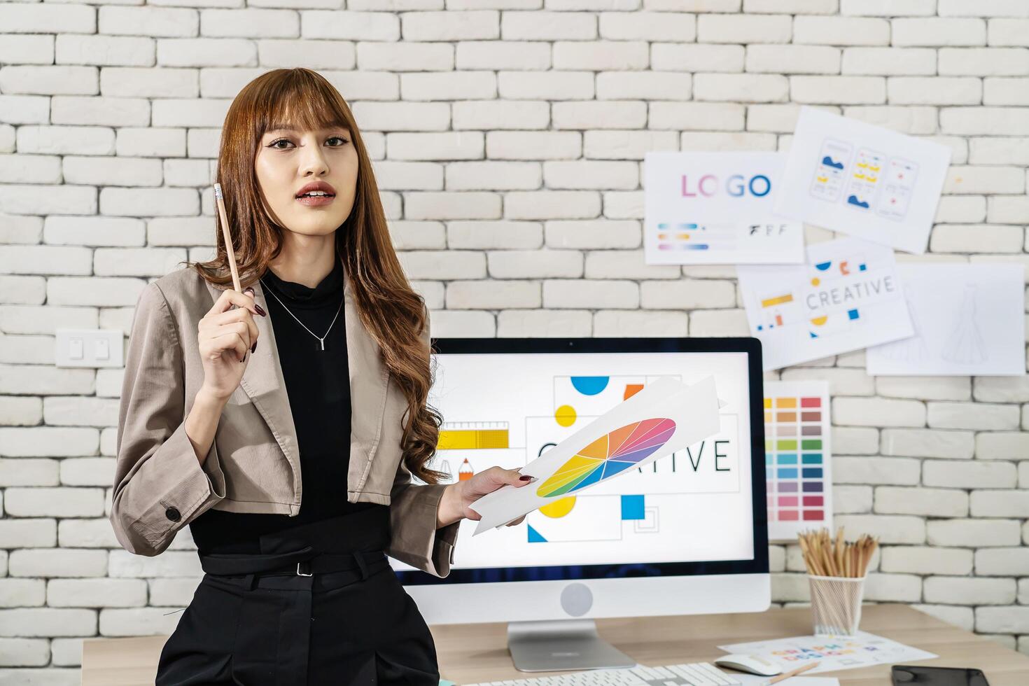 Young asian woman graphic designer working in office. Artist Creative Designer Illustrator Graphic Concept, corporate women in creative marketing team working on project management, looking camera photo