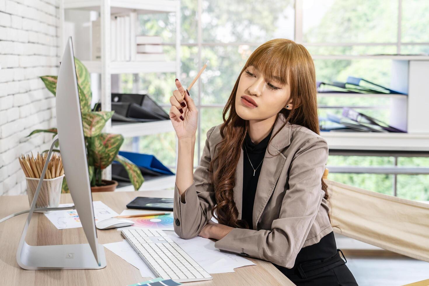 Young asian woman graphic designer working in office. Artist Creative Designer Illustrator Graphic Skill Concept, corporate women in creative marketing team working on project management, thinking photo