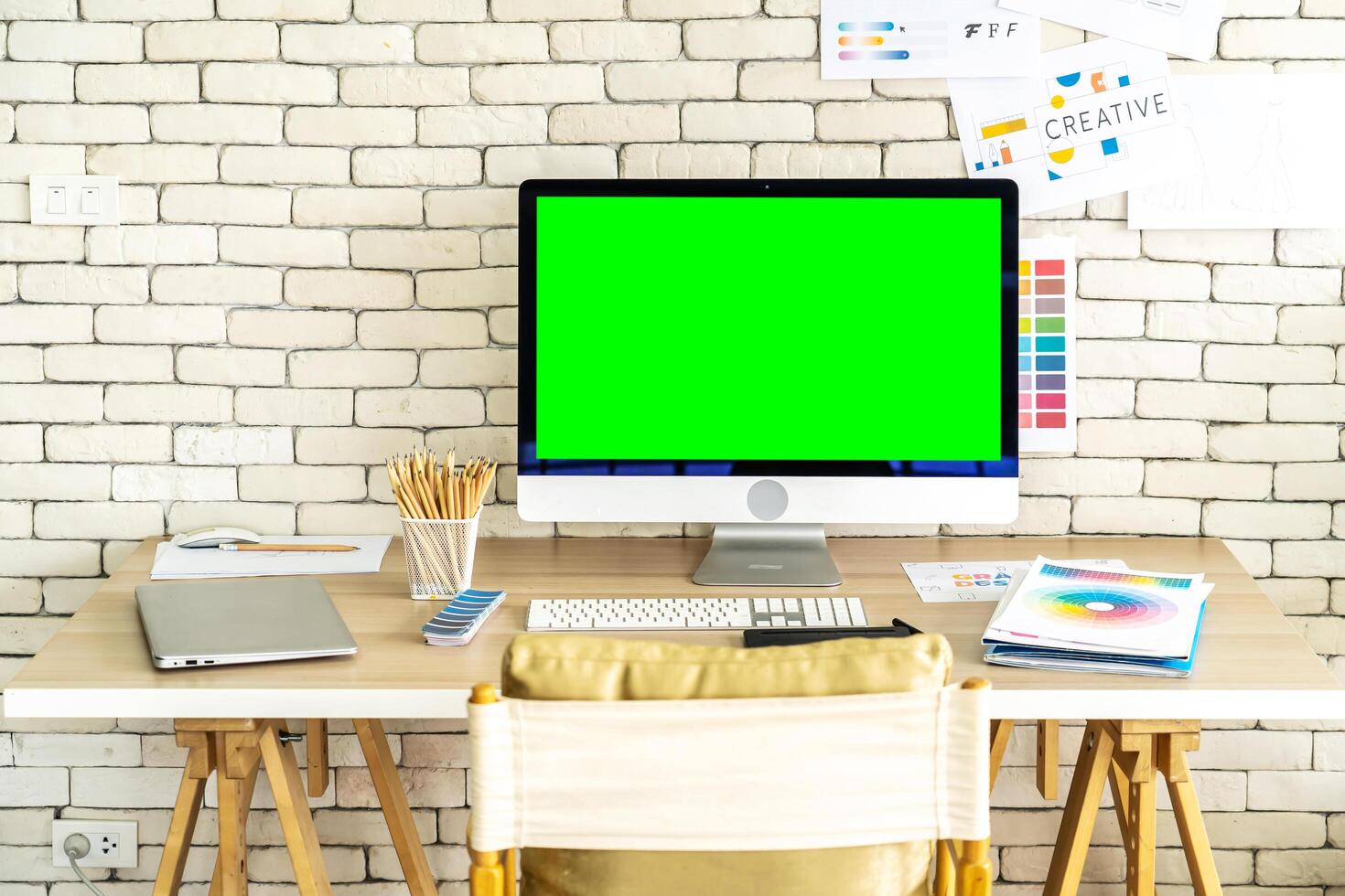 Laptop computer with green screen - white table with mouse and smartphone. Home interior or office background photo
